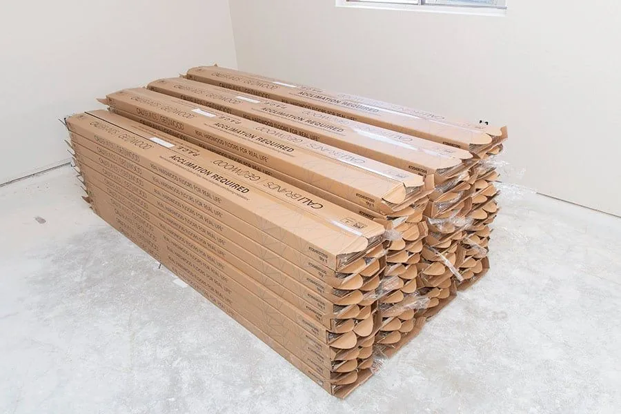 Cajas de piso laminado distribuidas dentro del espacio climatizado para aclimatarse, separadas de las paredes exteriores.