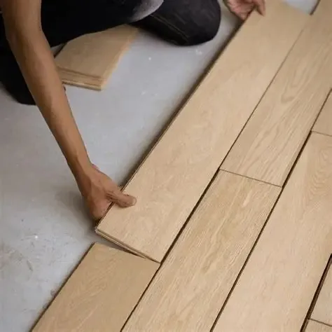 Varias filas de tablas colocadas en seco sobre el subsuelo para previsualizar el patrón antes de fijarlas.