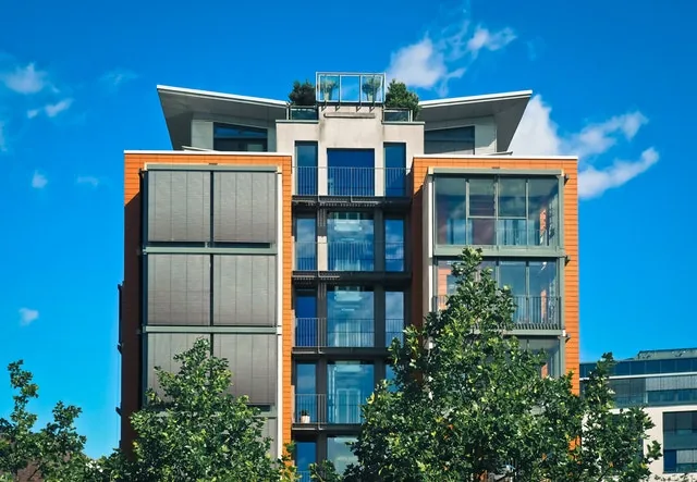 Edificio comercial moderno en una zona de redesarrollo urbano, del tipo que persigue certificación LEED o WELL como argumento de venta.