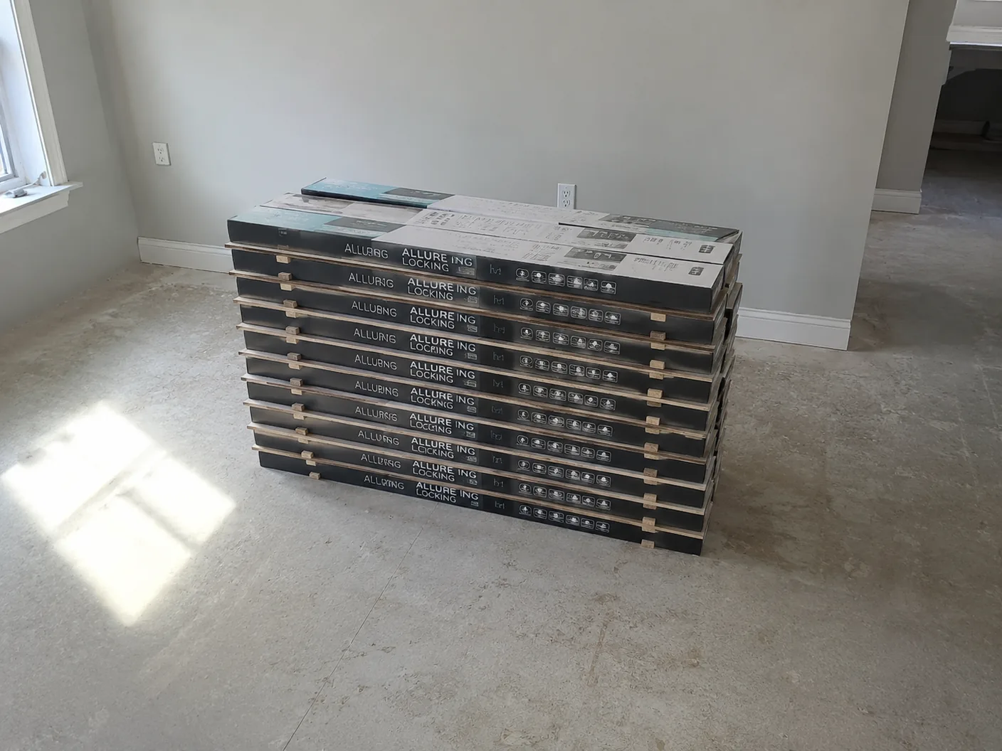 Primer plano de cajas de piso apiladas con separadores de madera entre capas para permitir la circulación de aire durante la aclimatación.